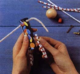 Проденьте скрученные вместе ершики через отвергши в верхнем конце трубки, чтобы получились руки куклы.