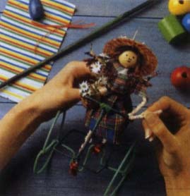Обмотайте туловище куклы куском двухсторонней липкой ленты. Оденьте куклу и завяжите ленточку вокруг талии.